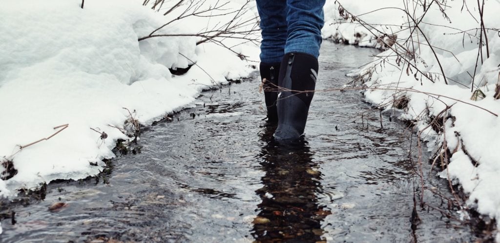 Dryshod rubber boots worn in a snowy stream